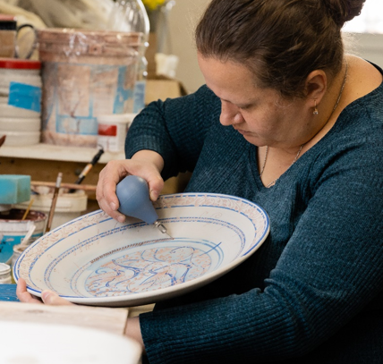 Oksana freehand draws the design on a custom blessing bowl for a very special gift.